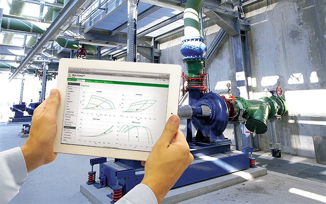 Engineer monitoring wastewater pump performance on a tablet in a treatment plant